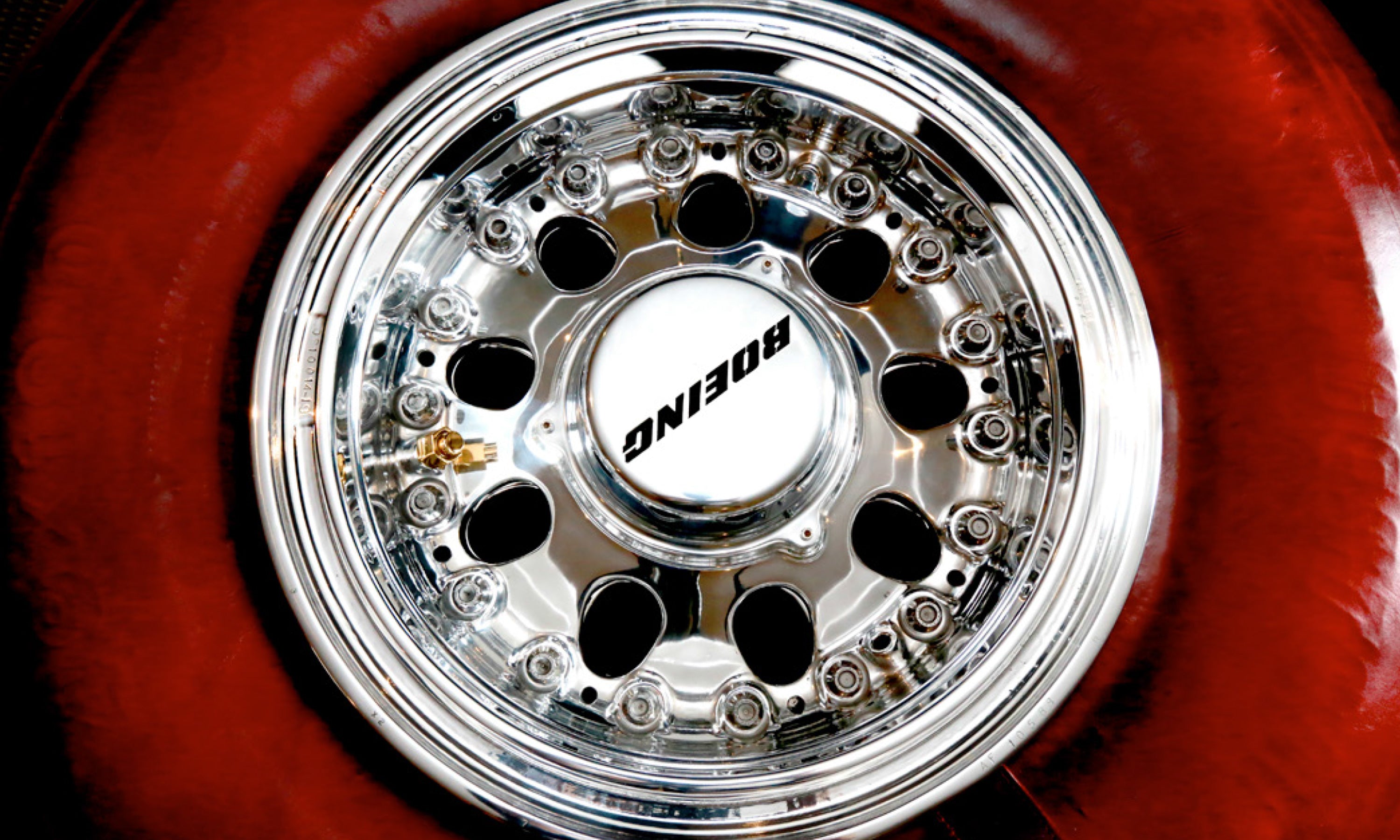 A Boeing 747 wheel coffee table with tire wrapped in red leather close up top